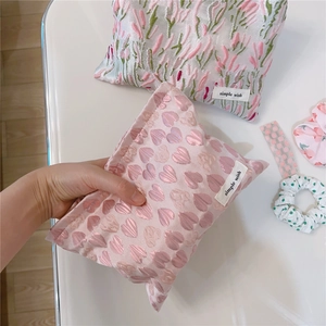 Detail of pink heart and green floral embroidered fabric makeup bags with simple wish label