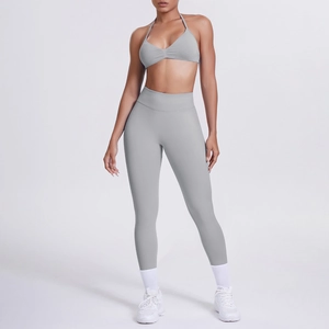 Dettaglio del reggiseno sportivo grigio e leggings yoga a vita alta su modella