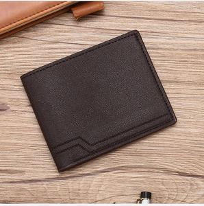 Detail of dark brown leather wallet with lychee pattern on a rustic wooden surface