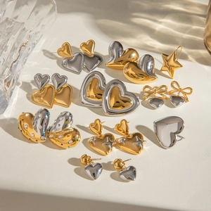 Polished gold and silver heart and star stud earrings set on a clean white background