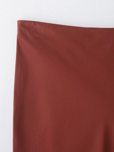 Detailed macro view of the rust red satin fabric with lace trim on the waist of a skirt