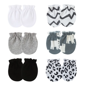 Detail of assorted newborn cotton anti-scratch mittens in solid colors and patterns