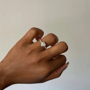 Close-up of elegant s925 silver heart shaped diamond ring worn on hand for engagement