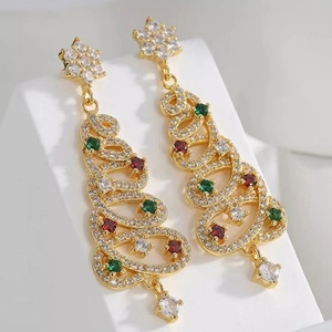 Macro shot of gold Christmas tree earrings with colorful stones and star-shaped details