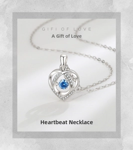 Detail of silver double heart necklace with a blue gemstone and sparkling zirconias