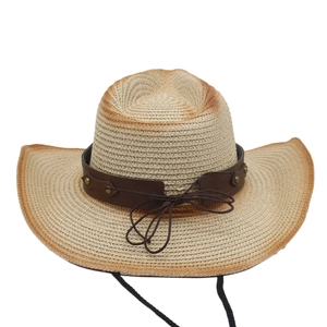 Detailed close-up of woven straw cowboy hat featuring vintage burnt edges and metal studs