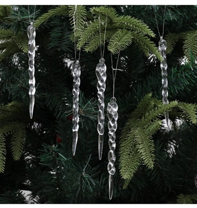 Close-up of five clear twisted icicle ornaments hanging on a dark green Christmas tree branch