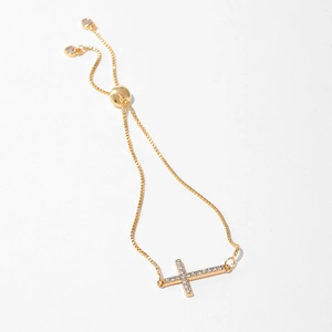 Detail of gold-plated cross bracelet with cubic zirconia and adjustable heart charms