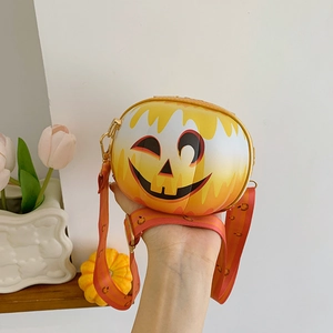 Detail of a round orange pumpkin face crossbody bag with wide shoulder strap