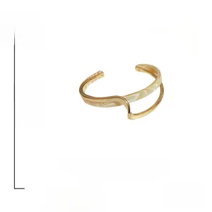 Detailed view of gold plated double-layered geometric bangle with shell texture inlay