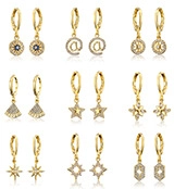 Nine pairs of golden zircon leaf and geometric earrings arranged in a professional grid