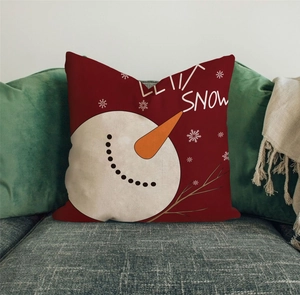 Nahaufnahme eines festlichen roten Kissenbezugs mit Schneemann auf grauem Sofa