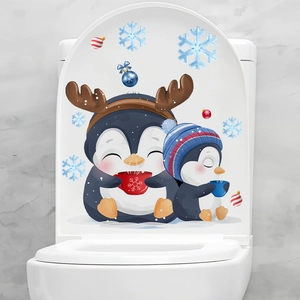 Close-up of Christmas toilet stickers featuring cartoon penguins and snowflakes