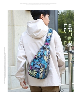 Detail of multi-functional chest bag with vibrant tropical leaf print and zipper pockets