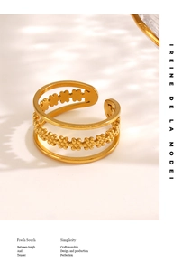 Macro shot of gold multilayer stainless steel ring with clover pattern and bead chain