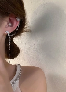 Macro detail of elegant celestial tassel earring with moon and star ear cuff design