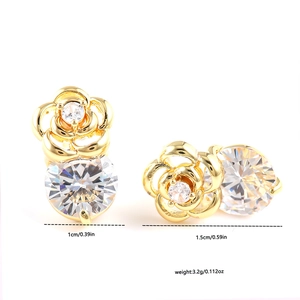 Boucles d'oreilles roses dorées avec zircons cubiques brillants sur un fond blanc pur