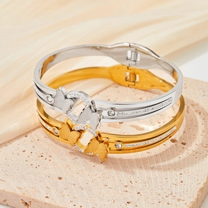 Minimalist stainless steel butterfly bangle with sparkling crystal accents in gold and silver