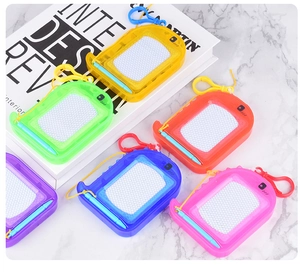 Close-up of six colorful dinosaur magnetic drawing boards with pens and clips on marble