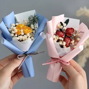 Mini dried rose bouquets with baby's breath in elegant blue and pink matte paper wraps