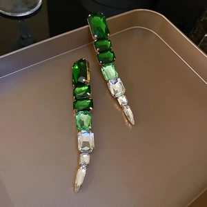 Detail of vintage gold drop earrings with emerald and clear stepped crystal stones