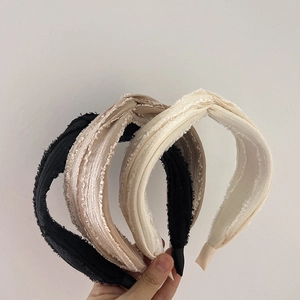 Close-up of four knotted wide headbands in black, beige, white, and champagne fabric