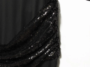 Detailed macro view of black sequin embellishments on midi dress fabric with shimmer