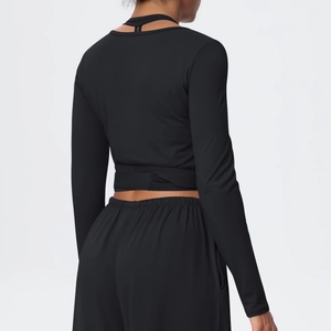 Detail of cross-strap back design and cutout on black long sleeve yoga top for women