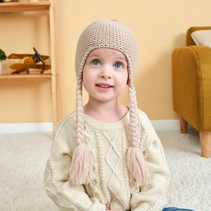 Beige knitted baby beanie with braided pigtails and warm fleece lining for kids