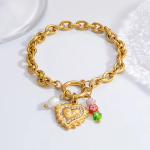 Detail of 18k gold chain with rhinestone heart, pearl, and colorful floral charms