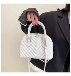 White shell handbag featuring V-quilted faux leather and golden double metal zippers