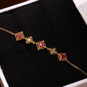 Makroaufnahme von Vintage Goldarmband mit quadratischen Rubinen und Diamanten auf Samt