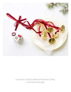 Detail of red velvet ribbons and golden bells on a decorative tray for Christmas