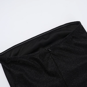 Detail of glittery black fabric showing fine texture and hidden zipper on the dress