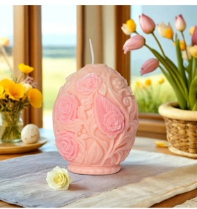 Dettaglio del rilievo di rose rosa e foglie su una candela profumata ovale decorata