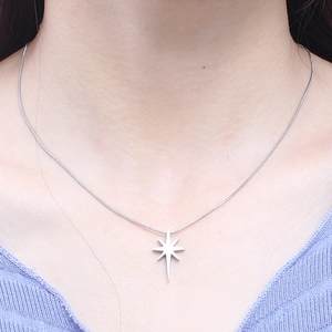 Silver star pendant necklace with cubic zirconia on snake chain shown on model