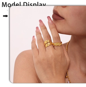 Detail of adjustable golden feather ring and geometric pave ring with textured finish