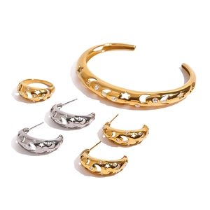 Star-shaped cutout jewelry set with gold and silver bracelets, rings, and earrings