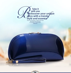 Close-up of royal blue patent leather shell bag with gold hardware and zipper detail