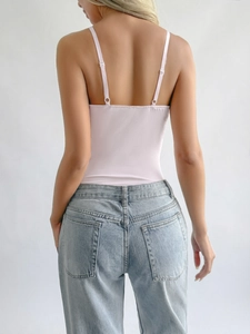 Detailed back view of a pink strap bodysuit paired with light blue denim jeans