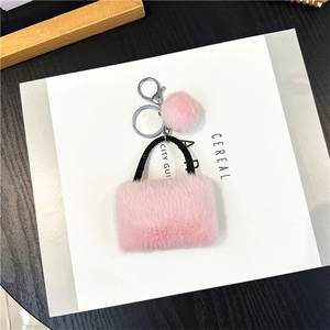 Detailed view of pink plush handbag keychain with silver ring and matching pompom charm