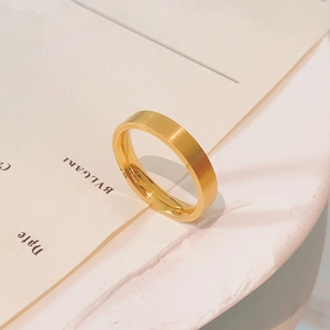 Close-up of a matte 18k gold plated stainless steel ring on a textured surface