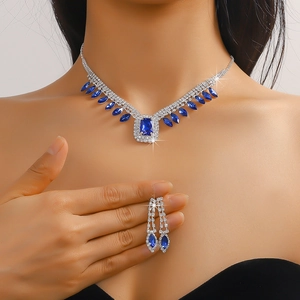 Close-up of blue crystal necklace set with marquise and emerald cut gemstones on model
