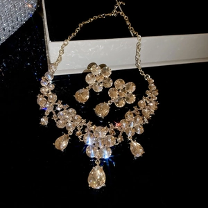 Detailed view of floral water drop necklace and earrings set with sparkling crystals