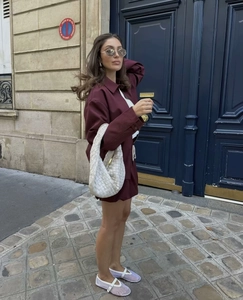 Burgundy jacket and shorts set with white woven tote bag on a Paris street background