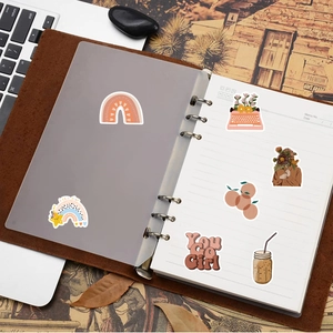 Detailed view of Bohemian waterproof stickers applied to a journal on a wooden desk