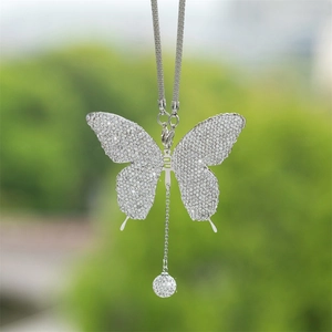 Close-up of sparkling rhinestone butterfly car pendant with silver metal hanging chain