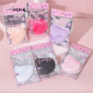 Detailed view of colorful triangular makeup puffs with finger straps in clear bags
