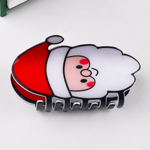 Gros plan d'une pince à cheveux Père Noël festive avec une finition brillante sur blanc