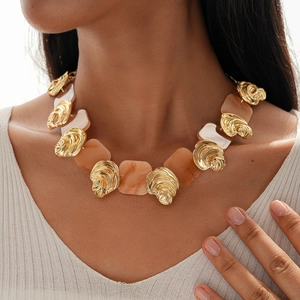 Detail view of model wearing a vintage resin square and gold irregular textured necklace